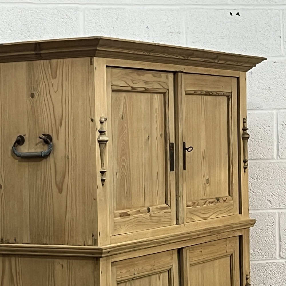 A three-section antique pine campaign cupboard featuring panelled doors, iron carrying handles on the sides, and rounded bun feet. View IX