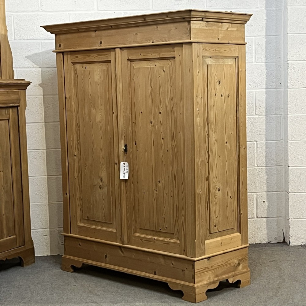 A freestanding 1930s double pine wardrobe featuring twin recessed panel doors, a moulded top cornice, and a natural timber grain. View IV