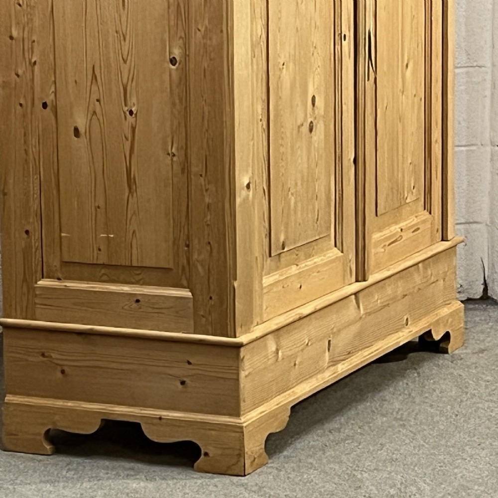 A freestanding 1930s double pine wardrobe featuring twin recessed panel doors, a moulded top cornice, and a natural timber grain. View VII
