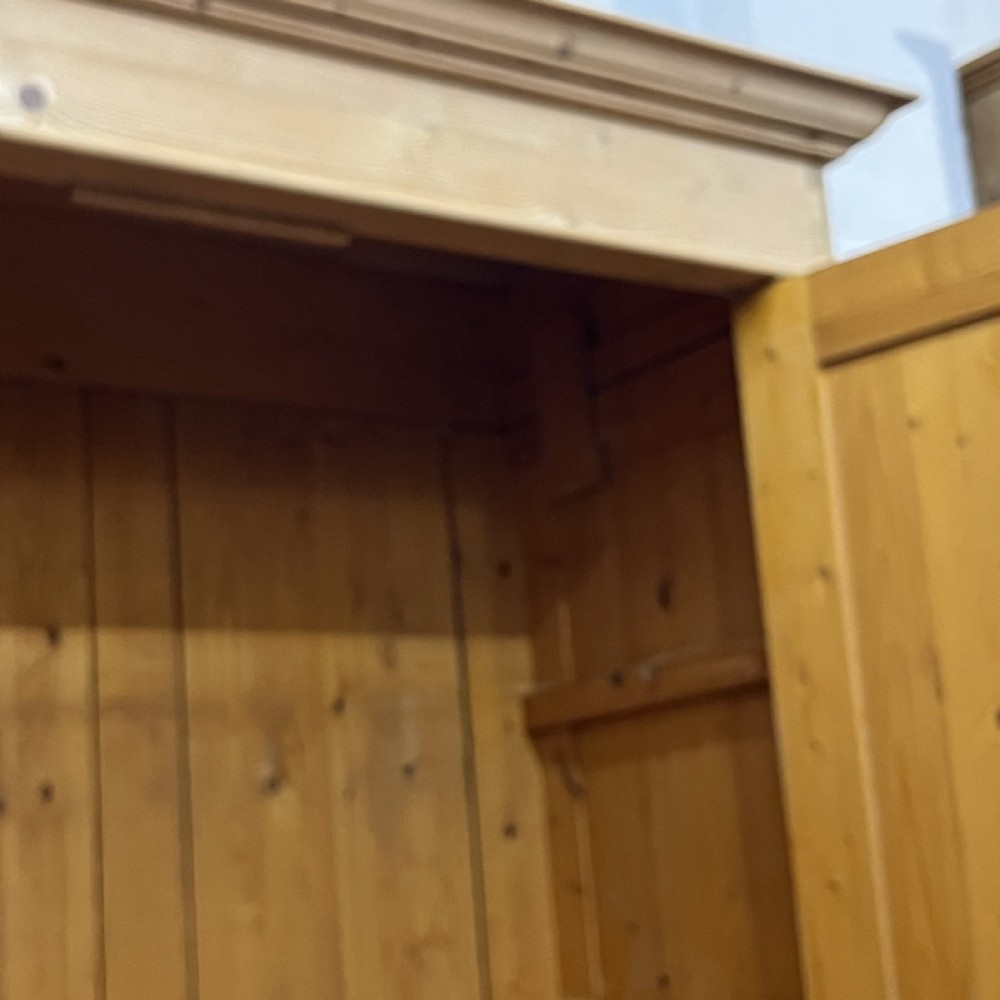 A freestanding 1930s double pine wardrobe featuring twin recessed panel doors, a moulded top cornice, and a natural timber grain. View IX