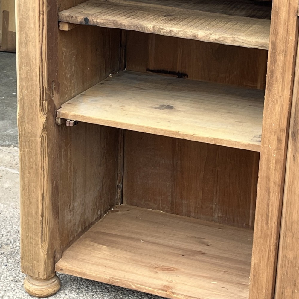 An antique natural pine church lectern cupboard featuring a hinged sloped top, single panelled door, and turned bun feet. View VI