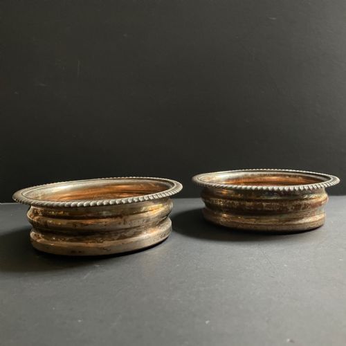 fig 1. A pair of antique Georgian Old Sheffield Plate wine coasters featuring gadrooned rims and turned wooden bases.