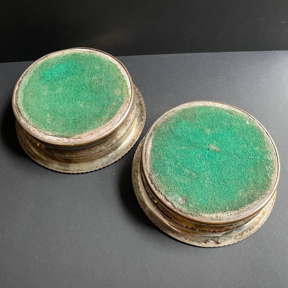 A pair of antique Georgian Old Sheffield Plate wine coasters featuring gadrooned rims and turned wooden bases. View VI