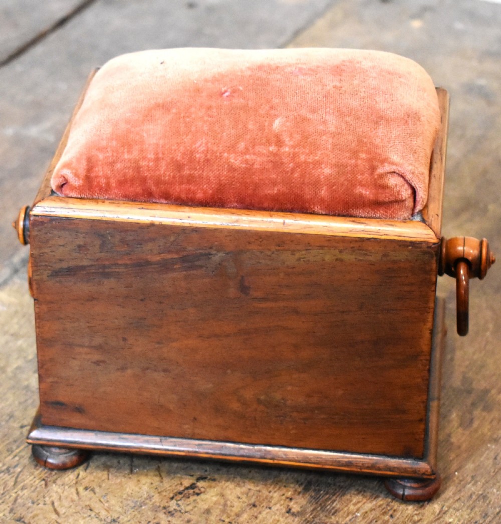 A small rectangular rosewood workbox featuring a terracotta velvet pincushion top, side handles, turned feet, and a drawer with inlaid diamond motifs. View V