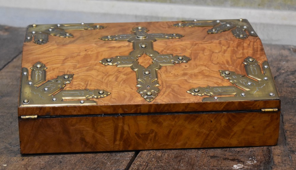 A closed rectangular wooden writing slope crafted from highly figured ash timber with ornate brass straps and corner mounts. View II