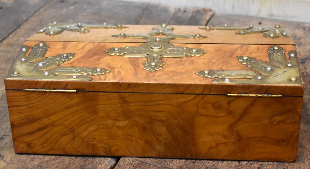 A closed rectangular wooden writing slope crafted from highly figured ash timber with ornate brass straps and corner mounts. View III
