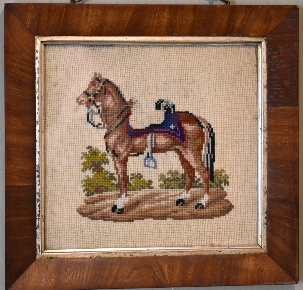 A square framed Victorian needlework picture depicting a brown saddled horse standing in a landscape within a wide wooden frame with a gilded inner slip. View II