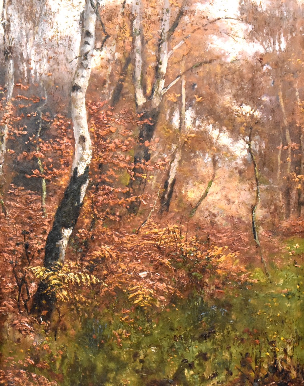 An oil painting depicting an autumnal woodland with birch trees and foliage, set within a wide bevelled gilded frame. View V