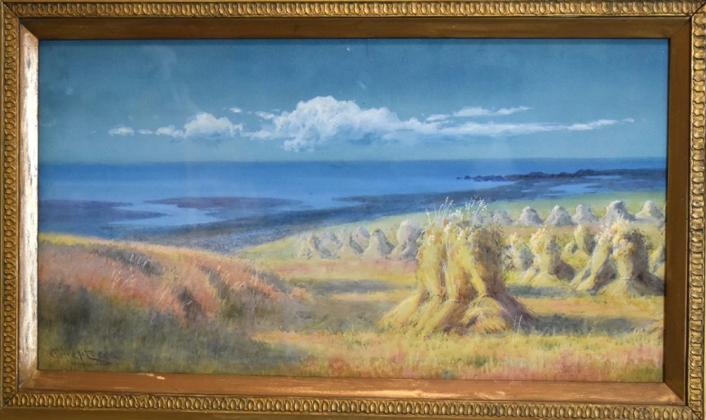 A framed watercolour painting depicting hay stooks in a field overlooking a blue bay under a cloudy sky, presented in a decorative gilt frame. View III