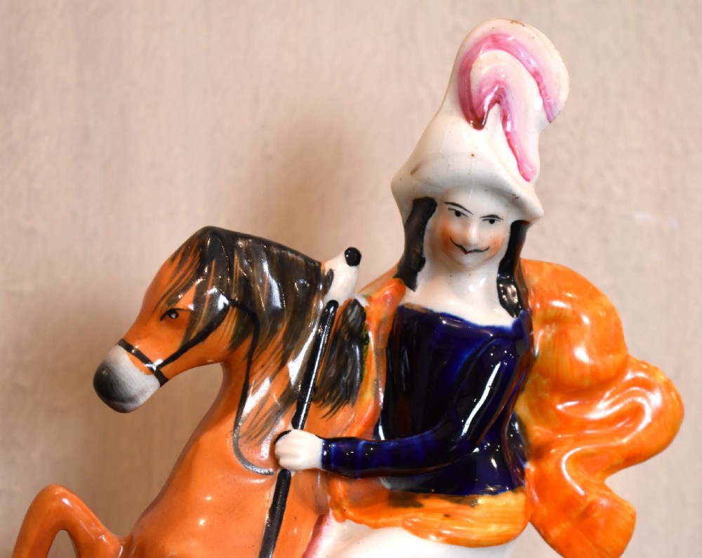 A Victorian Staffordshire earthenware figure depicting an equestrian hunter with a spear riding an orange horse over a spotted leopard on a moulded base. View III