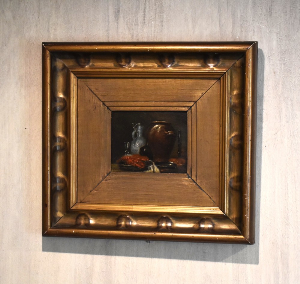 An 18th-century miniature oil painting depicting a dark still life composition with pottery and glass, housed within a wide gilt wood frame.