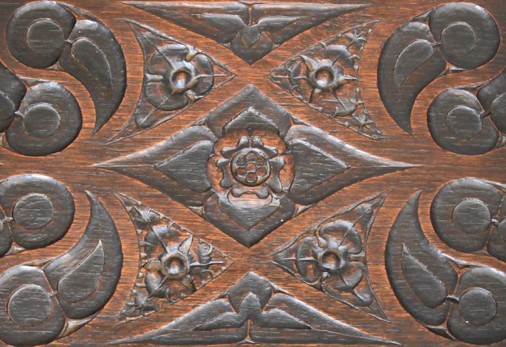 A rectangular dark carved oak box featuring intricate Gothic Revival relief carvings on the top lid and front panels. View III