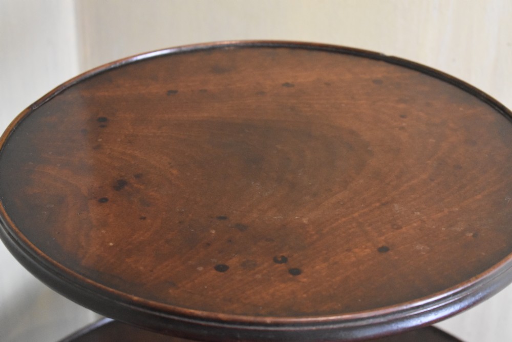 A Georgian mahogany three-tiered dumb waiter with graduated circular trays on a central turned stem supported by tripod cabriole legs with brass castors. View VI