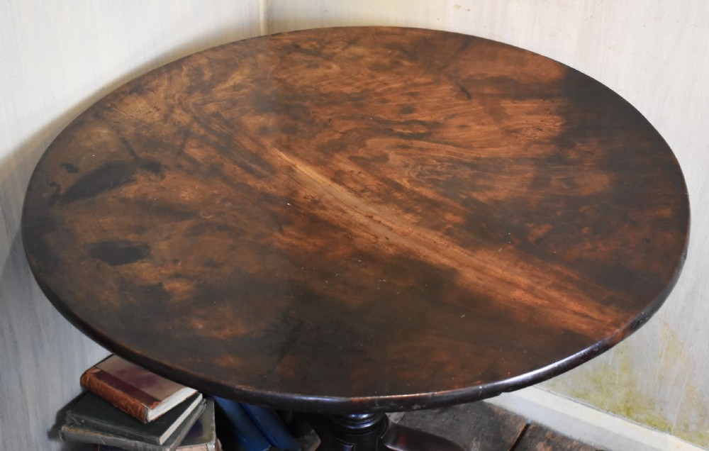 An 18th-century Georgian mahogany tilt-top table featuring a circular surface, a turned central pedestal, and three splayed cabriole legs. View III