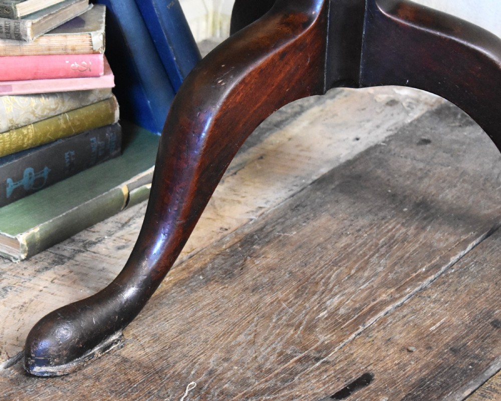 An 18th-century Georgian mahogany tilt-top table featuring a circular surface, a turned central pedestal, and three splayed cabriole legs. View VI