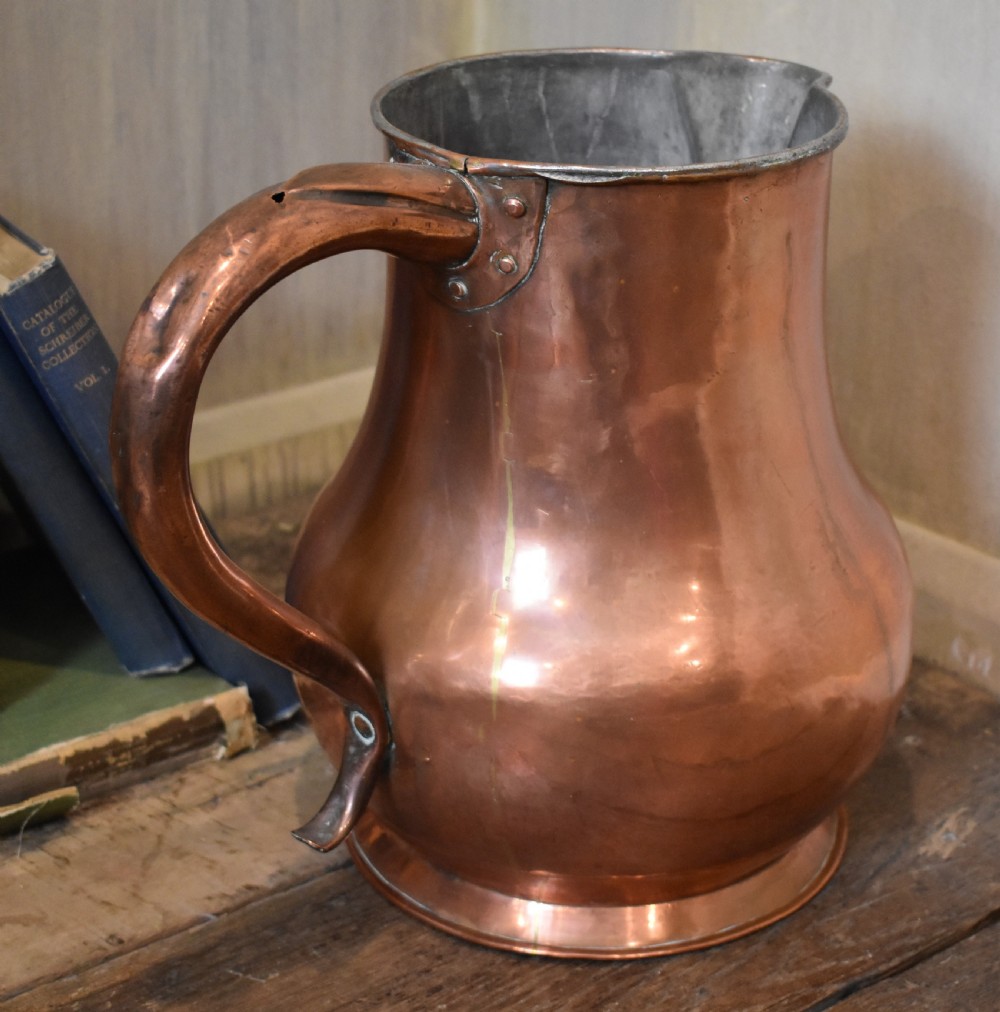 A large Georgian hand-hammered copper jug featuring a rounded baluster body, shaped pouring spout, heavy looped handle, and tin-lined interior. View II