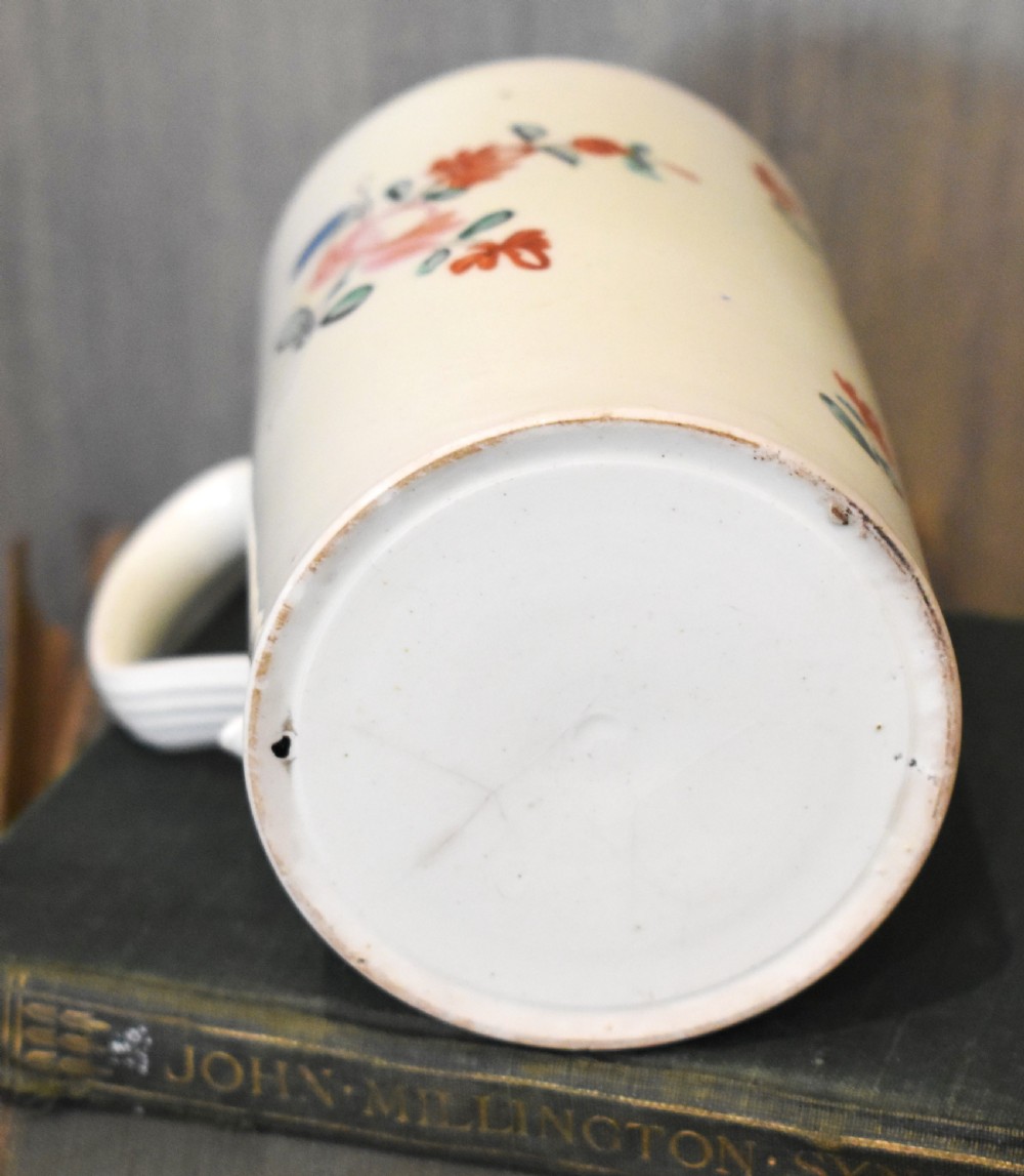 A cylindrical creamware ceramic tankard decorated with hand-painted polychrome floral motifs and a loop handle. View IV