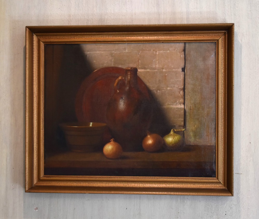 A framed oil painting depicting a rustic still life arrangement with a stoneware flagon, a terracotta bowl, and three onions on a wooden ledge.