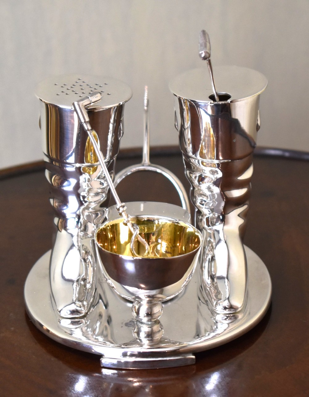 A silver-plated novelty equestrian cruet set featuring a riding boot mustard pot with a spur handle, a cap pepper shaker, and a gilt-lined salt cellar on a fitted tray. View V