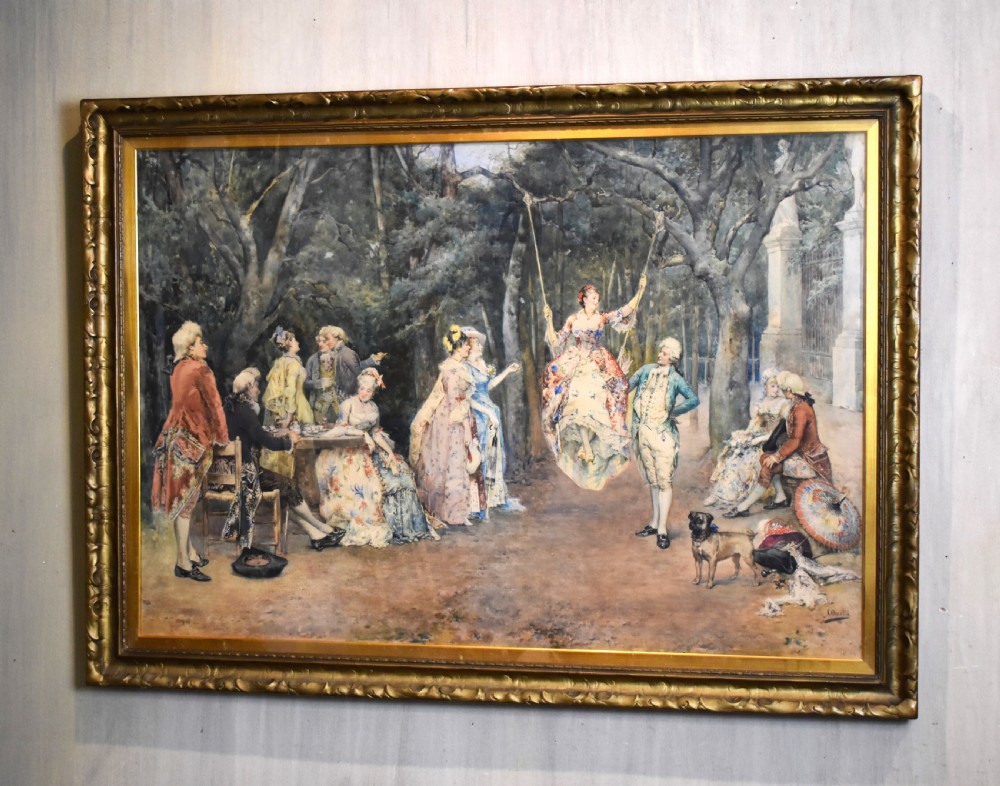 A large framed watercolour painting by Arturo Orselli depicting figures in 18th-century period attire gathered at a garden party with a woman on a swing.