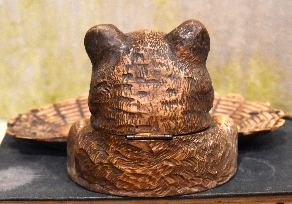 A carved wooden Black Forest inkwell featuring the detailed head of a cat with glass eyes positioned behind a basketweave pen tray. View VI