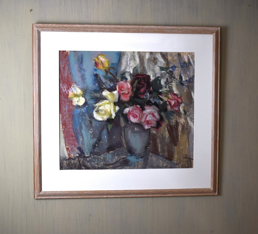 A framed pastel still life artwork depicting yellow, pink, and dark red roses in a grey vase against a blue backdrop.