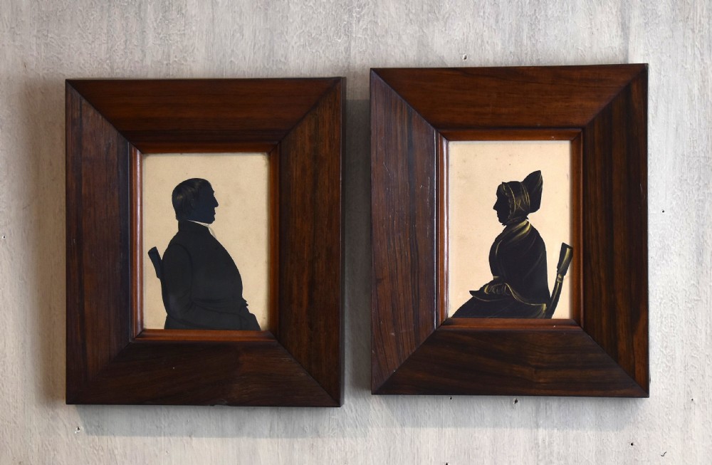 A pair of framed Victorian profile silhouettes depicting a man and a woman in polished dark wood frames. View II