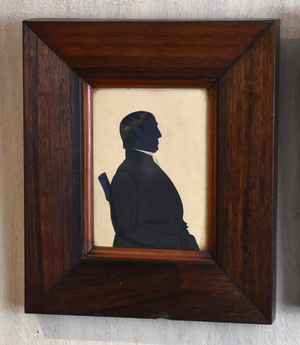 A pair of framed Victorian profile silhouettes depicting a man and a woman in polished dark wood frames. View III