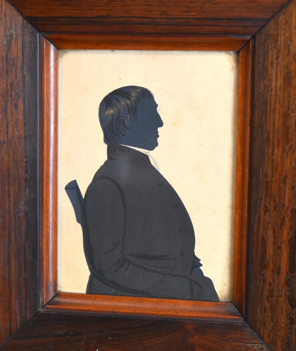 A pair of framed Victorian profile silhouettes depicting a man and a woman in polished dark wood frames. View IV