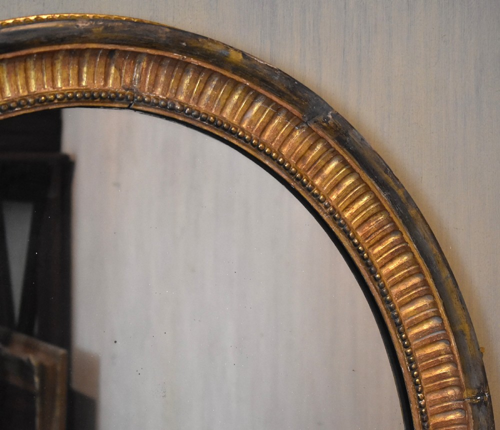 Large early nineteenth century oval gilt mirror View II