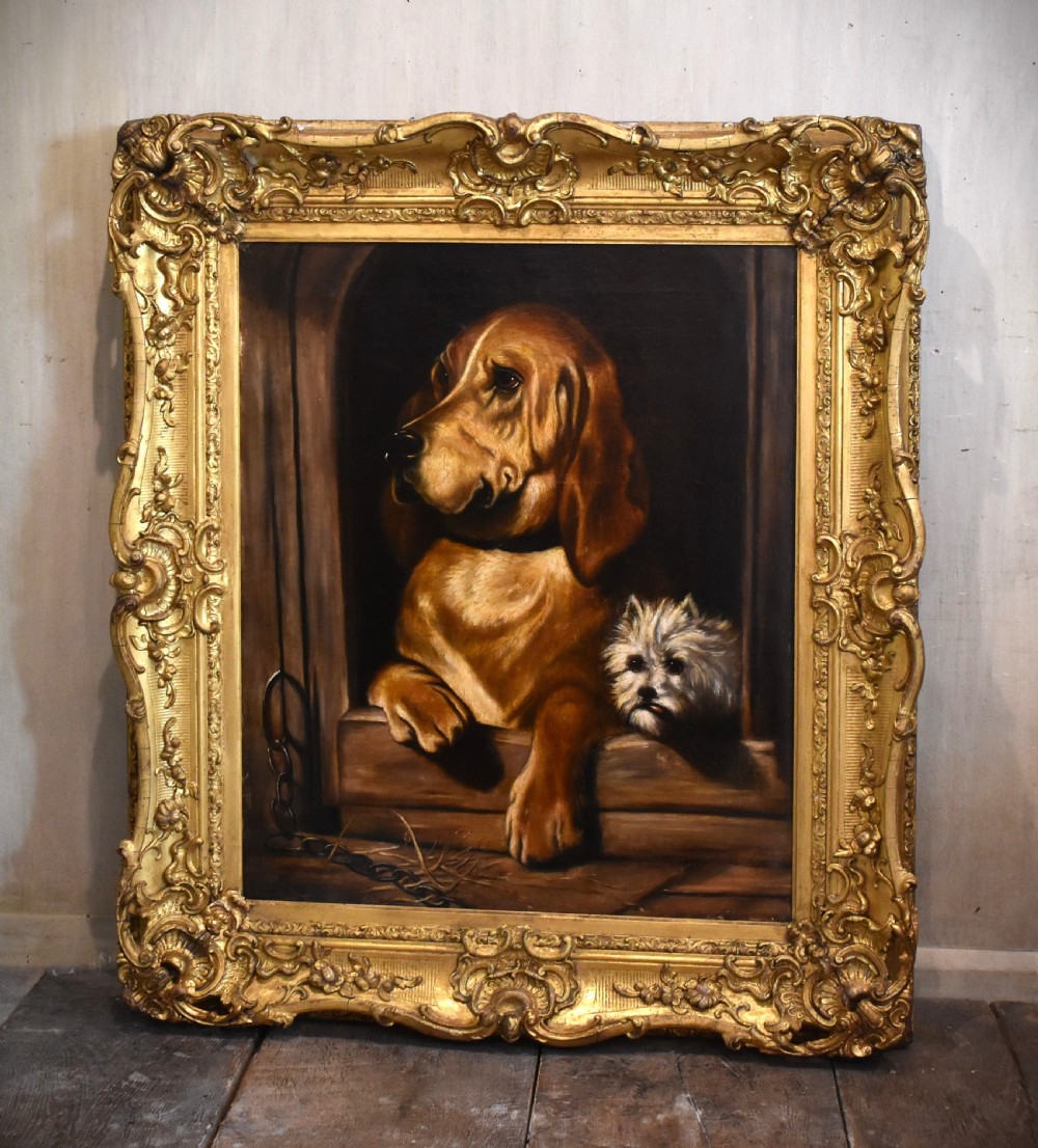 An oil painting depicting a large brown hound and a small white terrier peering from a dark wooden structure within a carved gold frame.