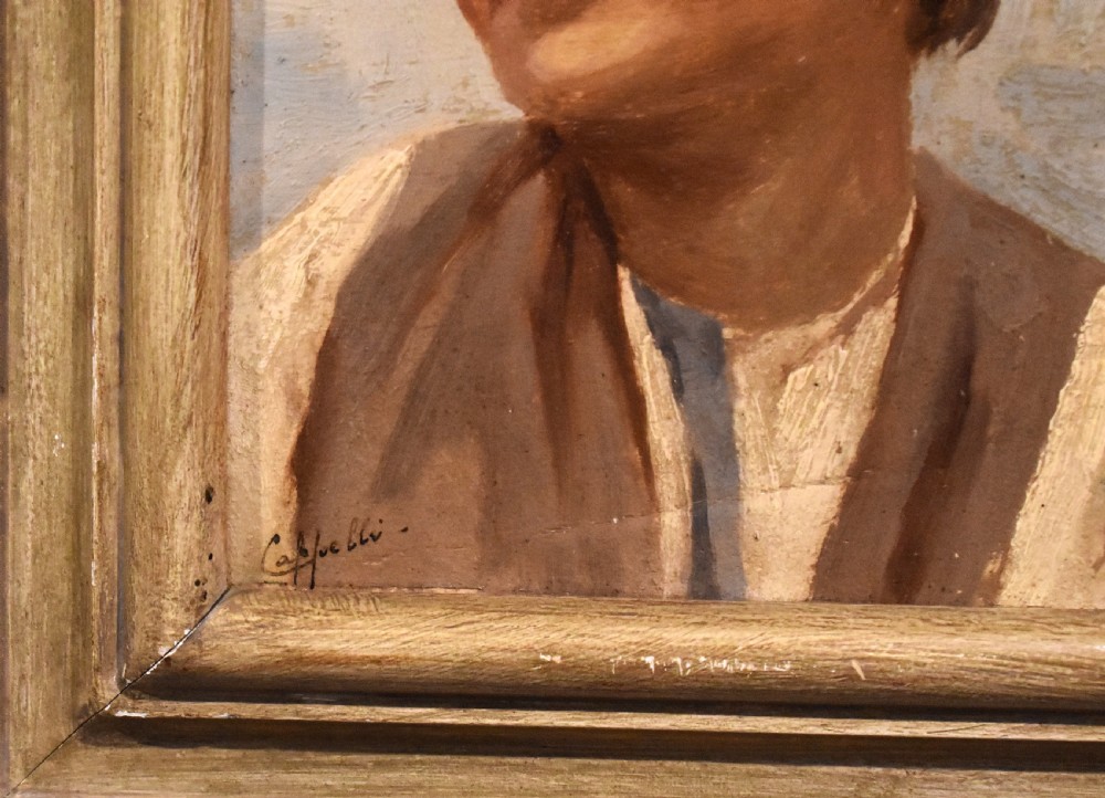 A framed oil painting depicting a smiling young boy wearing a cap and brown vest set within a moulded wooden frame. View V
