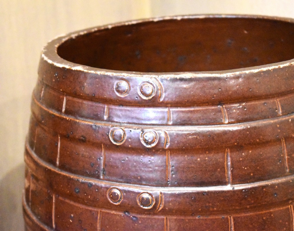 A large dark brown saltglaze stoneware stick stand moulded in the shape of a barrel with simulated staves and metal hoops. View IV