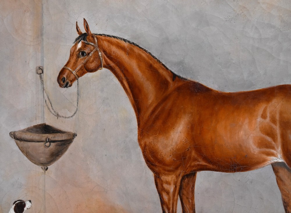 An antique oil painting depicting a chestnut horse and a small dog inside a stable setting, presented in a polished timber frame with a gold inner slip. View V