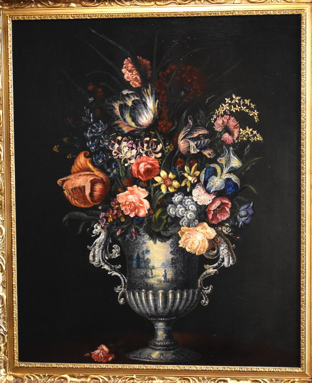 An eighteenth-century style floral still life oil painting depicting a colourful bouquet in a detailed urn, housed within an ornate carved giltwood frame. View III