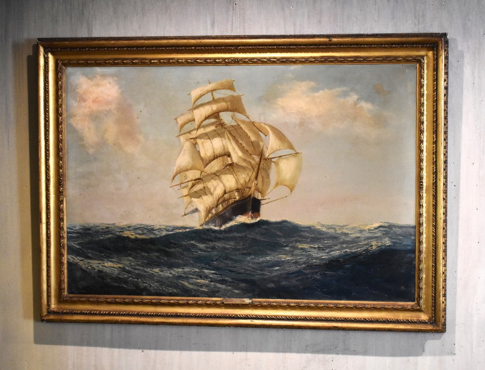 An oil painting depicting a multi-masted clipper ship navigating ocean waves, presented within a gilded wooden frame.