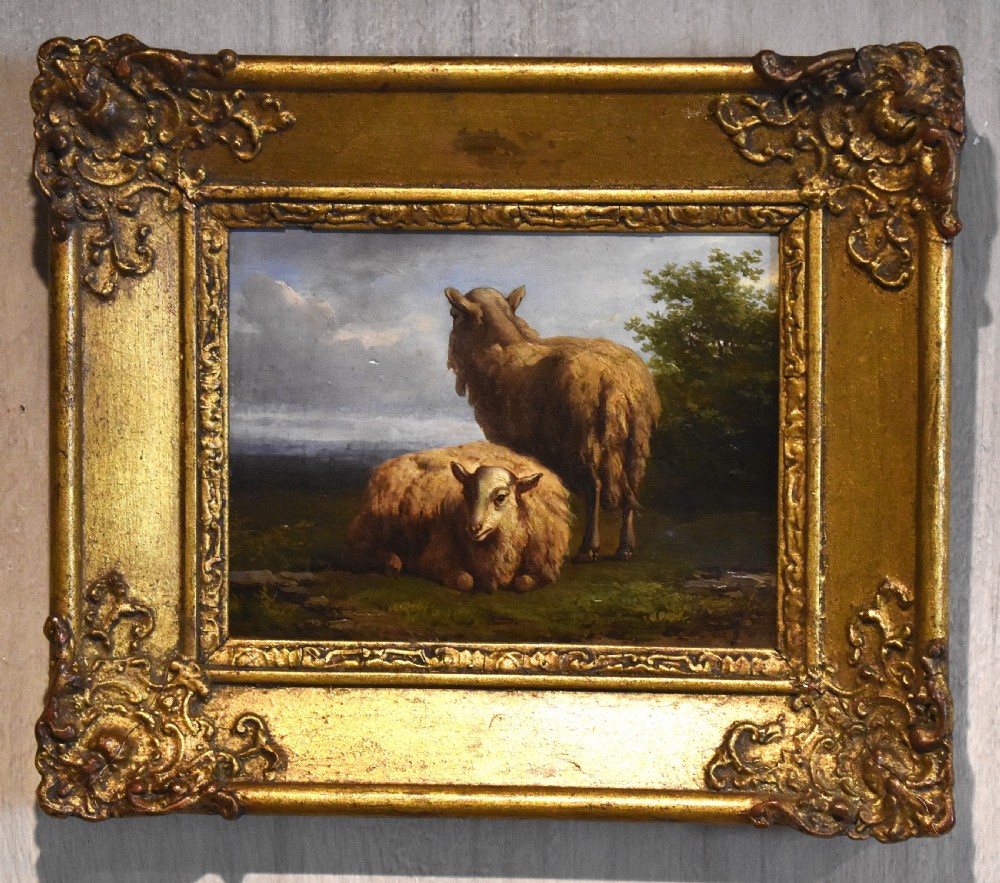 A small 19th-century pastoral oil painting depicting two sheep in a landscape, set within an ornate gilded frame with scrolled corner detailing. View II