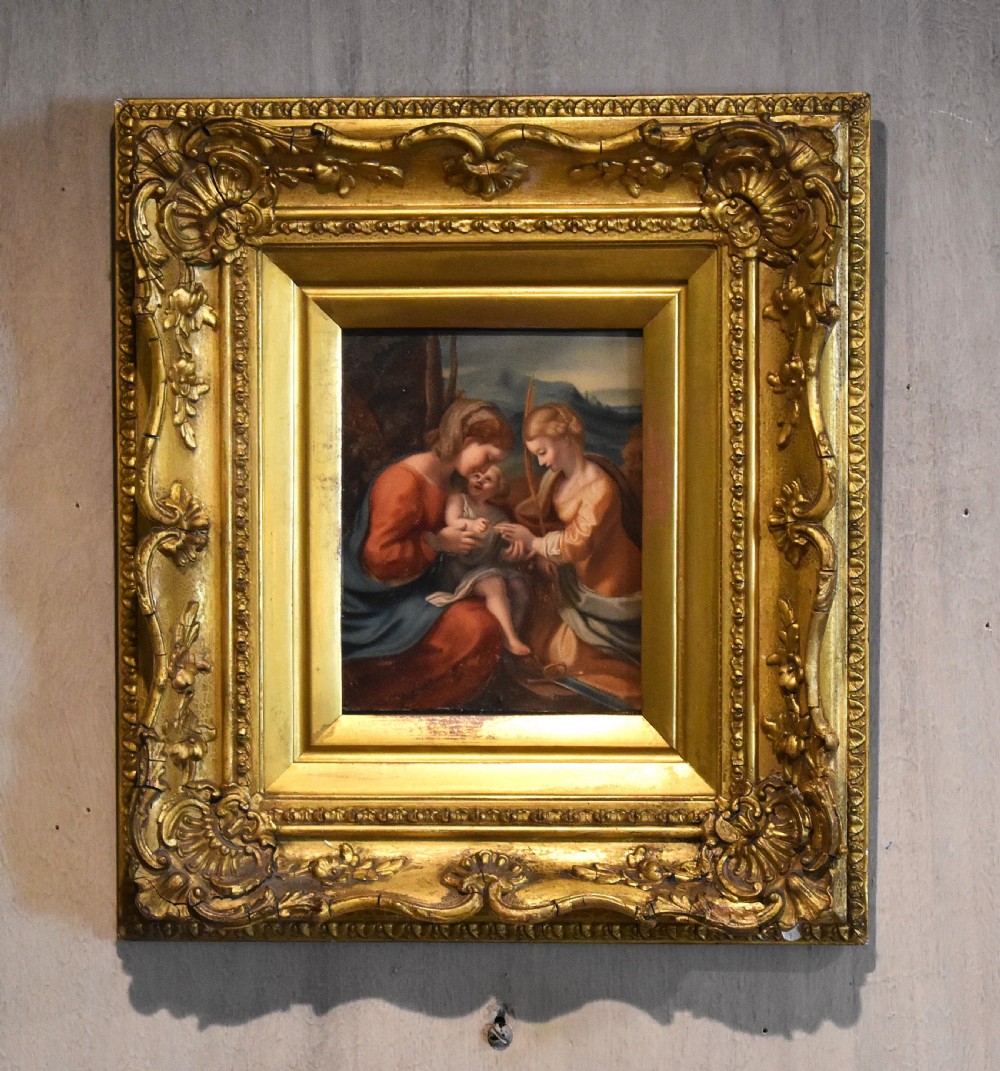 A small framed watercolour painting depicting the Madonna and Child with Saint Catherine set inside a gilded carved wood frame.