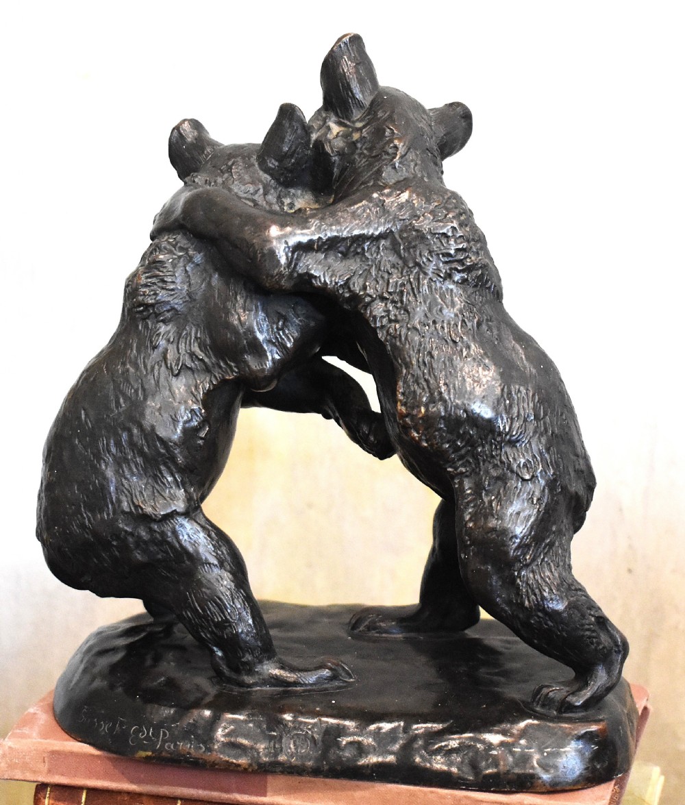 A dark patinated bronze sculpture depicting two play-fighting bear cubs standing on an integral naturalistic bronze base. View IV