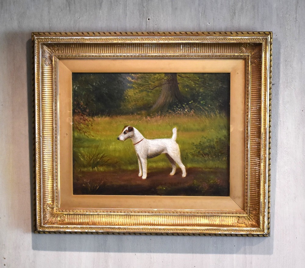 An oil painting of a white terrier standing in profile in a green field within a gilded frame.
