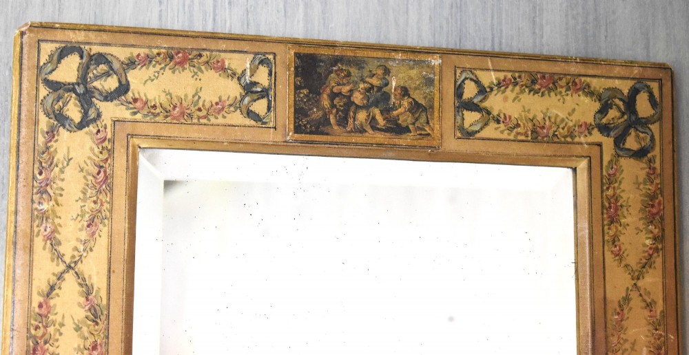 A rectangular wall mirror featuring a bevelled glass pane surrounded by a wide frame decorated with hand-painted silk motifs including ribbon bows, floral swags, and central medallions. View III