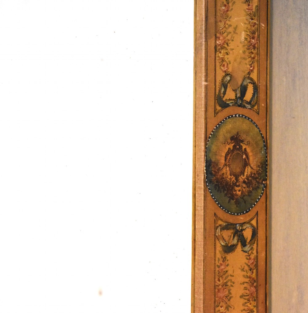 A rectangular wall mirror featuring a bevelled glass pane surrounded by a wide frame decorated with hand-painted silk motifs including ribbon bows, floral swags, and central medallions. View V