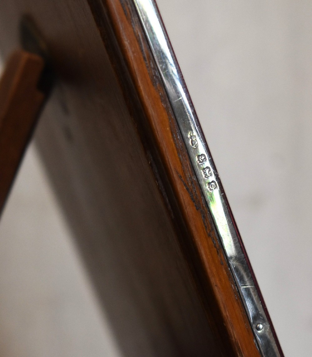 An upright rectangular Art Deco silver picture frame with textured engine-turned detailing around the border and a blue insert. View VI
