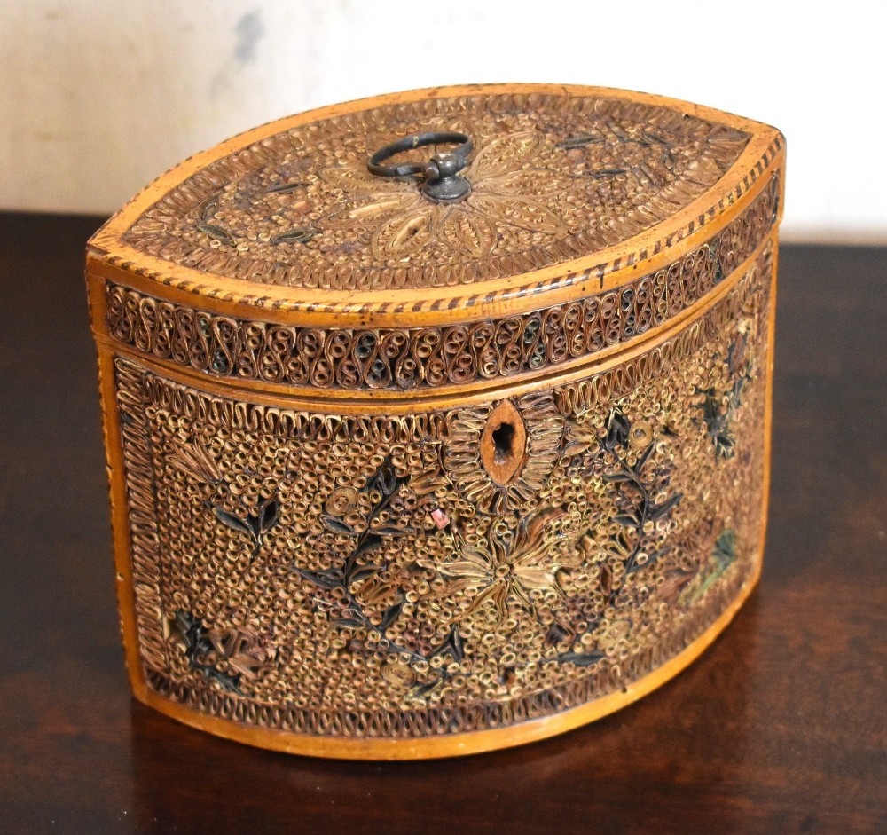 A late 18th-century Georgian navette-shaped tea caddy covered entirely in tight quilled paper scrolls with central floral panels. View II
