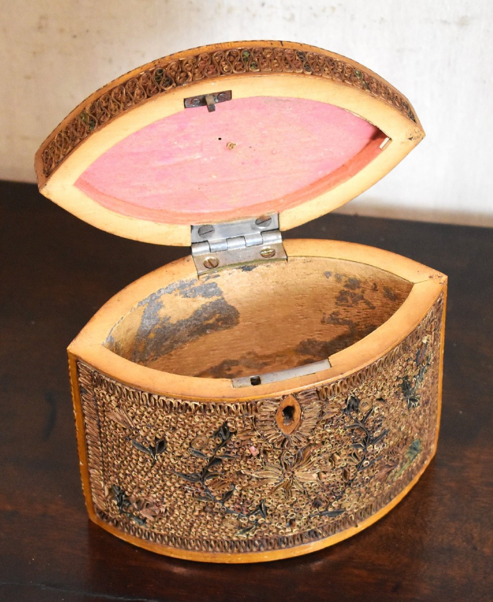 A late 18th-century Georgian navette-shaped tea caddy covered entirely in tight quilled paper scrolls with central floral panels. View V