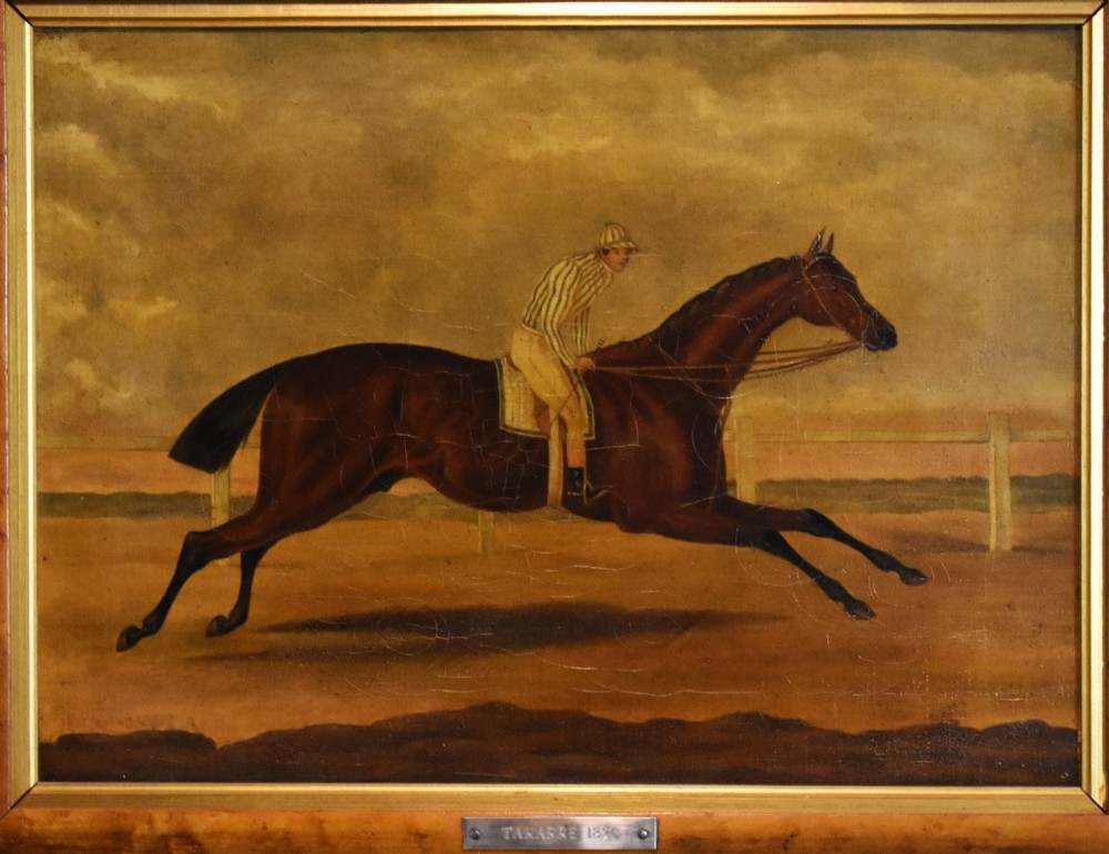 A vertical pair of framed antique sporting prints depicting racehorses and jockeys set in golden maple frames with brass title plaques. View IV
