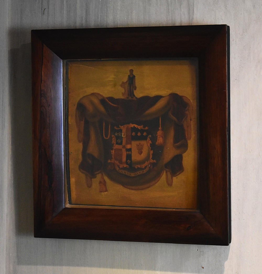 An antique Georgian painted wooden coach panel featuring a heraldic coat of arms within a thick dark mahogany frame.