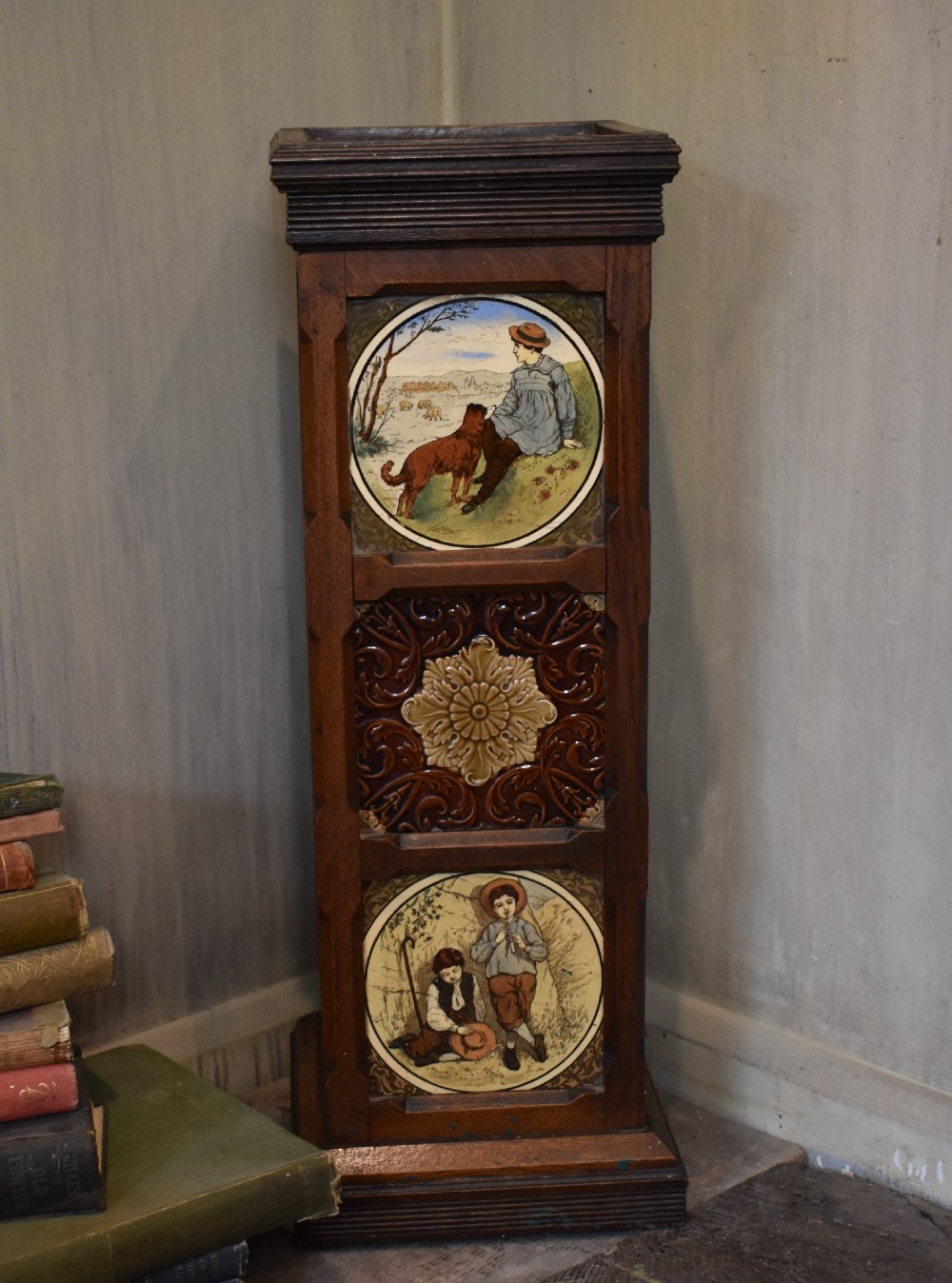 A dark wood Aesthetic Movement pedestal column with three vertical inset ceramic tiles displaying painted birds amidst foliage. View VII