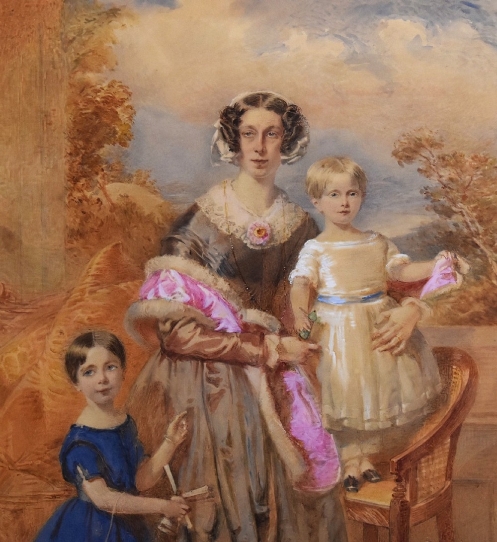 A mid-19th-century watercolour portrait depicting a mother with two young children, presented in a birds eye maple frame with a gold slip. View IV