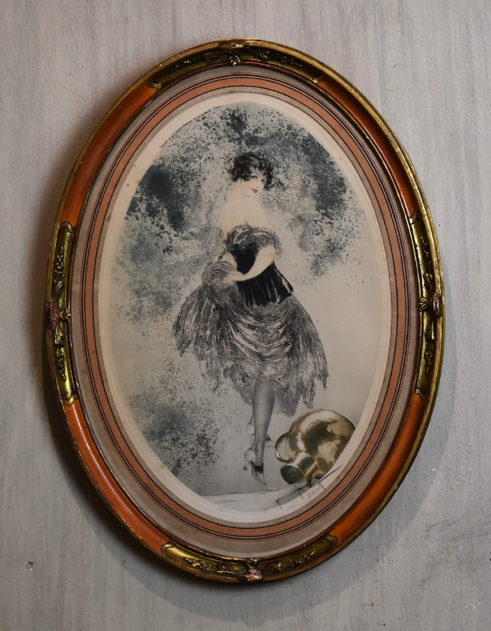 A set of three framed Art Deco fashion prints by Louis Icart featuring figures in 1920s gowns, presented in two oval and one rectangular gilt frames. View VII